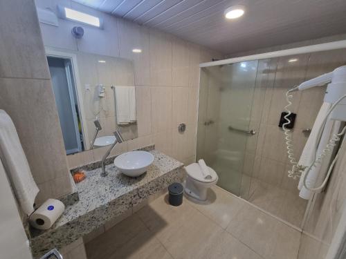 a bathroom with a shower and a sink and a toilet at Marambaia Hotel e Convenções in Balneário Camboriú
