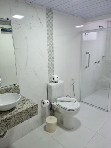 a bathroom with a toilet and a sink and a shower at Marambaia Hotel e Convenções in Balneário Camboriú