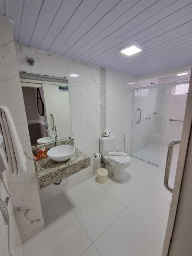 a bathroom with a toilet and a sink and a shower at Marambaia Hotel e Convenções in Balneário Camboriú