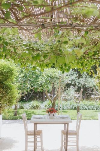 a white table with two chairs and a tree at Masseria Montelauro in Otranto