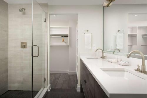 a bathroom with two sinks and a shower at Home2 Suites By Hilton Nashville Downtown Convention Center in Nashville