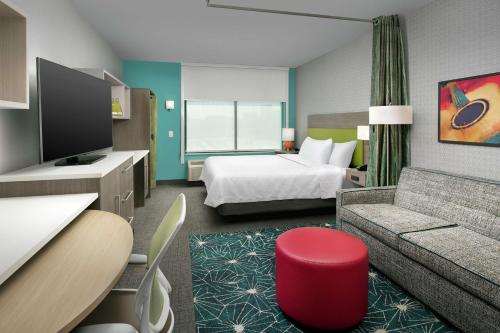 Habitación de hotel con cama y sofá en Home2 Suites By Hilton Nashville Downtown Convention Center, en Nashville