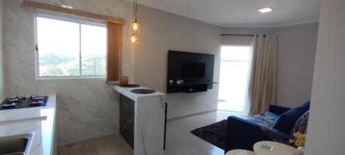 a small living room with a television and a living room at Apê Bella Vista Campos in Campos do Jordão
