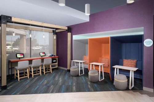 a room with a bar with stools and purple walls at Tru By Hilton Murfreesboro, Tn in Murfreesboro