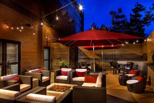 a patio with couches and a red umbrella at DoubleTree by Hilton Hotel Largo Washington DC in Largo