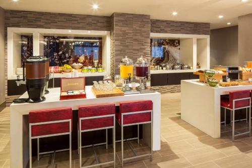 a restaurant with a bar with red bar stools at DoubleTree by Hilton Hotel Largo Washington DC in Largo