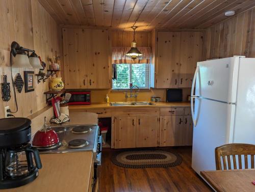a kitchen with wooden cabinets and a white refrigerator at Moore's Cabin in Miramonte