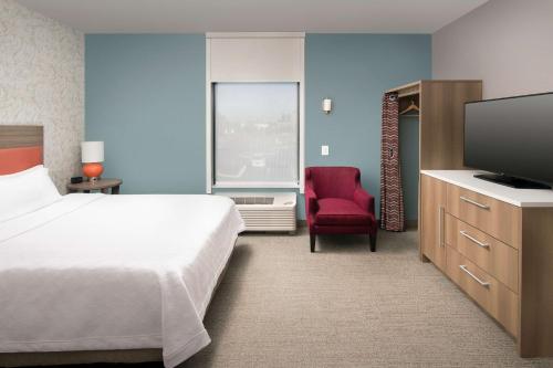 Home2 Suites By Hilton Murfreesboro في مورفريسبورو: غرفه فندقيه سرير وتلفزيون