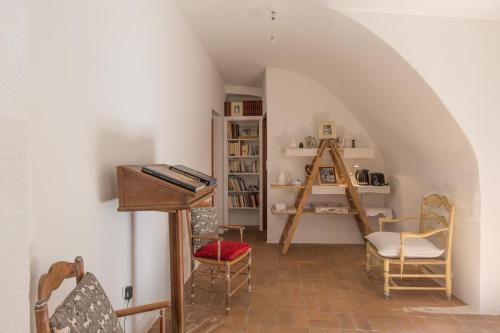 a attic room with a piano and a ladder at Studio au Piano in Saint-Siffret