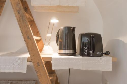 a microwave and a toaster sitting on a shelf at Studio au Piano in Saint-Siffret