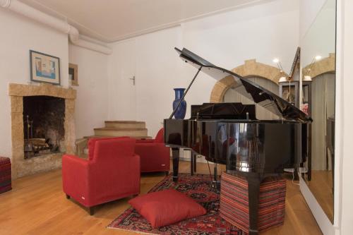 a living room with a piano and a red chair at Studio au Piano in Saint-Siffret