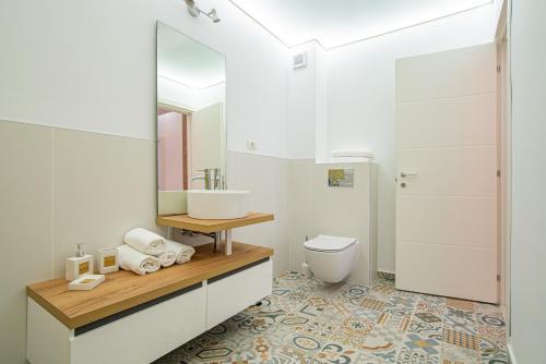 La salle de bains blanche est pourvue d'un lavabo et de toilettes. dans l'établissement GooApartments Five, à Mamaia Nord – Năvodari