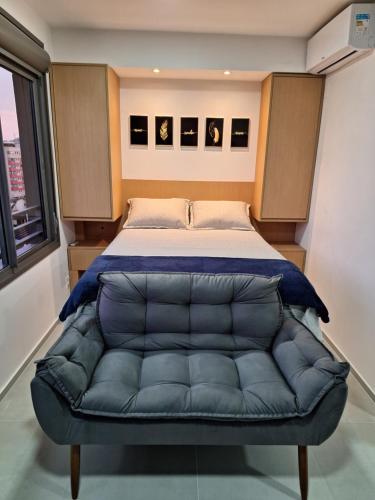 阿雷格里港的住宿－Lindo Studio NOVO no JP Redenção - Rofftop com vista espetacular，一间卧室配有一张带蓝色真皮沙发的床