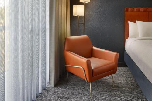 a orange chair in a hotel room with a bed at Courtyard by Marriott Nashville Brentwood in Brentwood
