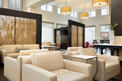 a living room with couches and a table and a room at Embassy Suites by Hilton Jackson North Ridgeland in Ridgeland