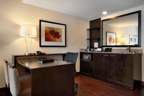 Pokój hotelowy z biurkiem i lustrem w obiekcie Embassy Suites by Hilton Jackson North Ridgeland w mieście Ridgeland