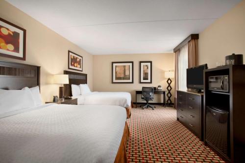 a hotel room with two beds and a television at Embassy Suites by Hilton Jackson North Ridgeland in Ridgeland