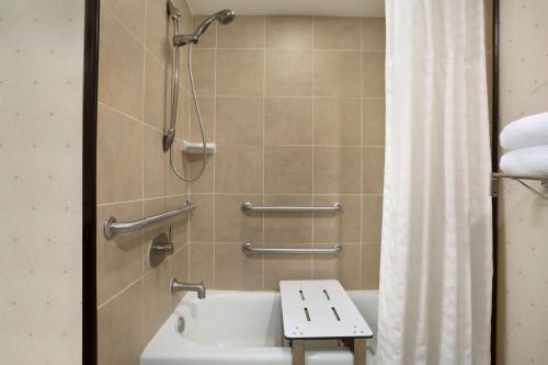 a bathroom with a shower and a tub and a sink at Embassy Suites by Hilton Jackson North Ridgeland in Ridgeland