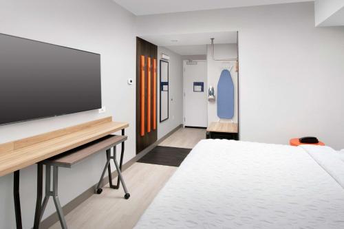 a bedroom with a bed and a flat screen tv at Tru By Hilton Louisville East Ky in Louisville