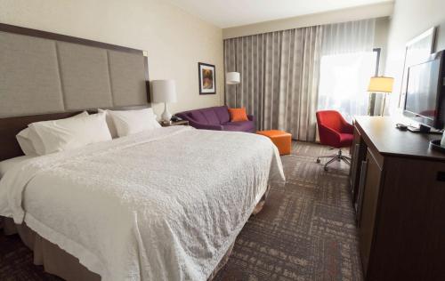 a hotel room with a bed and a television at Hampton Inn Sevierville in Sevierville