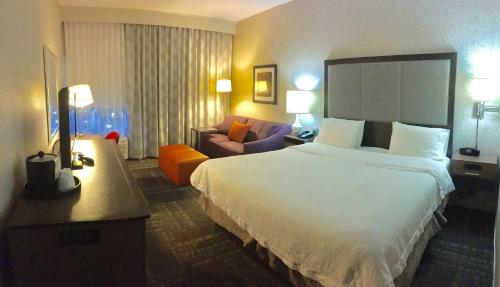a hotel room with a large bed and a couch at Hampton Inn Sevierville in Sevierville