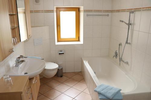 a bathroom with a tub and a toilet and a sink at Ferienhaus zum roten Traktor in Perl