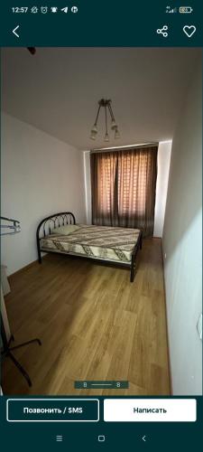 Квартира في Tridtsatʼ Let Kazakhstana: غرفة نوم بسرير وارضية خشبية