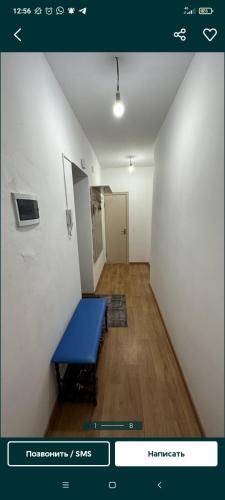 a hallway with a blue bench in a room at Квартира in Tridtsatʼ Let Kazakhstana
