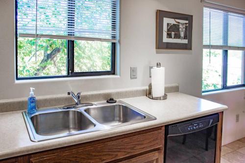 uma cozinha com um lavatório e duas janelas em Cowboys & Angels - Classic Sedona style w/great location em Sedona