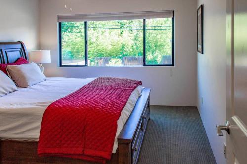 a bedroom with a bed with a red blanket and a window at Cowboys & Angels - Classic Sedona style w/great location in Sedona