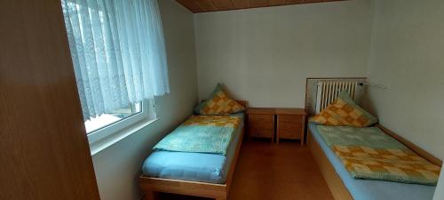 a small room with two beds and a window at Apartment Popp Langen in Langen