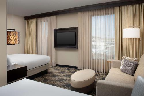 ノックスビルにあるEmbassy Suites by Hilton Knoxville Westのベッドとテレビが備わるホテルルームです。