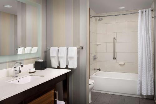 a bathroom with a tub and a toilet and a sink at Embassy Suites by Hilton Knoxville West in Knoxville