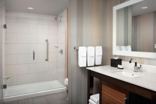 a bathroom with a shower toilet and a sink at Embassy Suites by Hilton Knoxville West in Knoxville