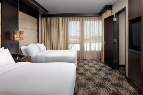 a hotel room with two beds and a flat screen tv at Embassy Suites by Hilton Knoxville West in Knoxville