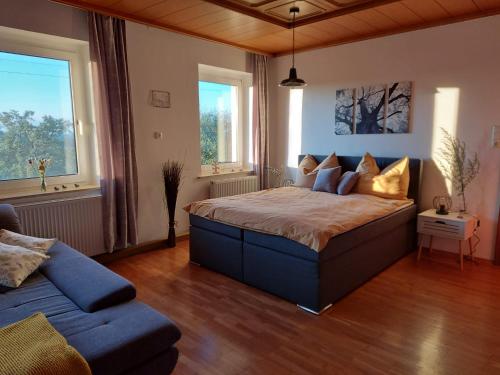 克雷姆斯明斯特的住宿－Wildkraut´s Kräuterbauernhof - Ferienwohnung，一间卧室配有一张大床和一张沙发