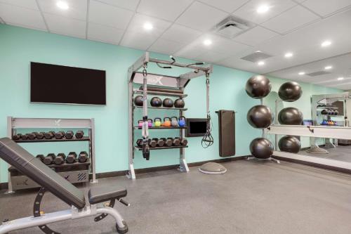 a fitness room with a gym with a flat screen tv at Tru By Hilton Jacksonville St Johns Town Center in Jacksonville