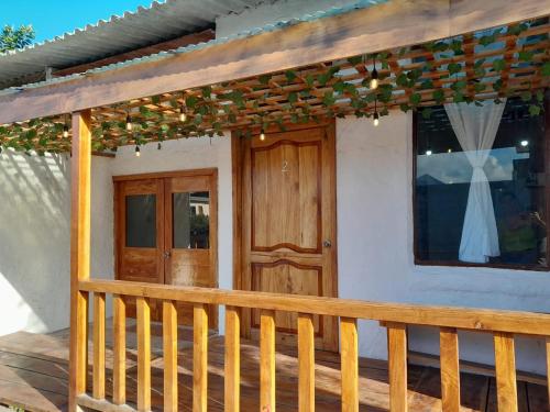 a porch of a house with a wooden door at Sky Blue Hospedaje in Puerto Villamil
