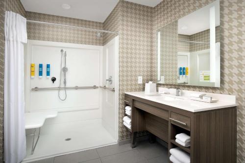 a bathroom with a tub shower and a sink at Home2 Suites By Hilton Columbia Southeast Fort Jackson in Columbia