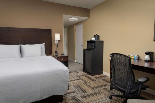 a hotel room with a bed and a desk and a chair at Hampton Inn Knoxville-East in Knoxville