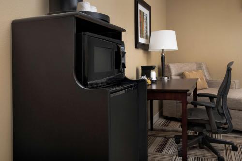 a television sitting on top of a refrigerator with a desk at Hampton Inn Knoxville-East in Knoxville
