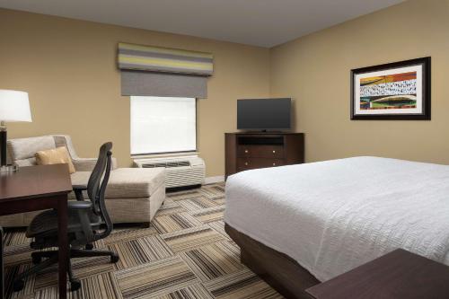 a hotel room with a bed and a desk and a computer at Hampton Inn Knoxville-East in Knoxville