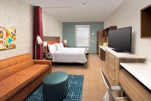 a hotel room with a bed and a television at Home2 Suites By Hilton Las Cruces in Las Cruces