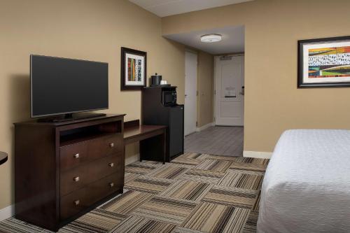 a hotel room with a bed and a television on a dresser at Hampton Inn Knoxville-East in Knoxville