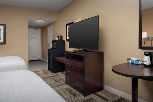 a hotel room with a bed and a flat screen tv at Hampton Inn Knoxville-East in Knoxville