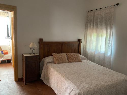 a bedroom with a large bed and a window at Apartamentos en sierra de gata la Noguera 2 in Villamiel