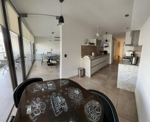 a kitchen and living room with a table in a room at Depto 3 amb zona Guemes con cochera, balcón a la calle con parrilla a gas in Mar del Plata