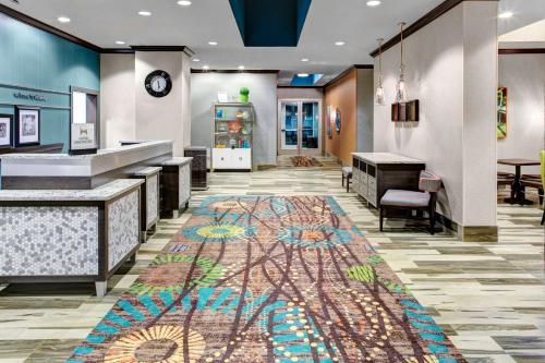 Hampton Inn & Suites by Hilton Atlanta Perimeter Dunwoody في أتلانتا: لوبى مع سجادة ملونة على الأرض