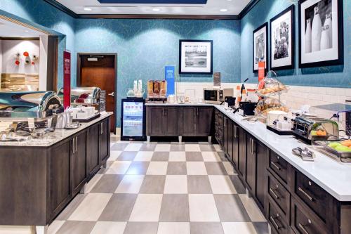 a large kitchen with blue walls and wooden cabinets at Hampton Inn & Suites by Hilton Atlanta Perimeter Dunwoody in Atlanta