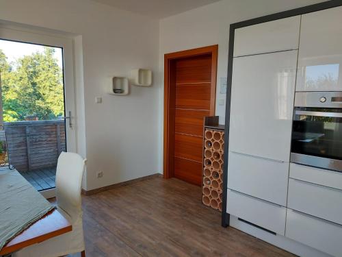 a room with a kitchen with a door and a table at Wildkraut´s Kräuterbauernhof - Ferienwohnung in Kremsmünster